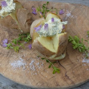 baked potatoes with butter on a wooden board